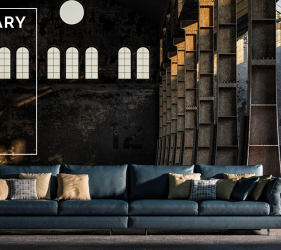 divano contemporaneo blu in pelle in una stanza in stile industriale da cui entra la luce che illumina