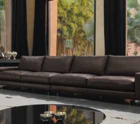 divano in pelle 4 posti illuminato da un ampia finestra in un salotto moderno