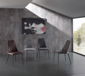 sedie di design in mezzo ad una stanza minimal grigia da cui entra un raggio di sole che illumina