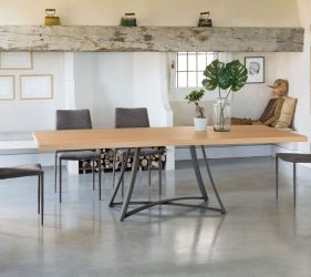 sala da pranzo con tavolo di design in legno e ferro e sedie grigie abbinate in una stabza moderna ed elegante con dettagli oro