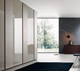 camera da letto minimal con ampio armadio scorrevole in vetro con arredamento moderno
